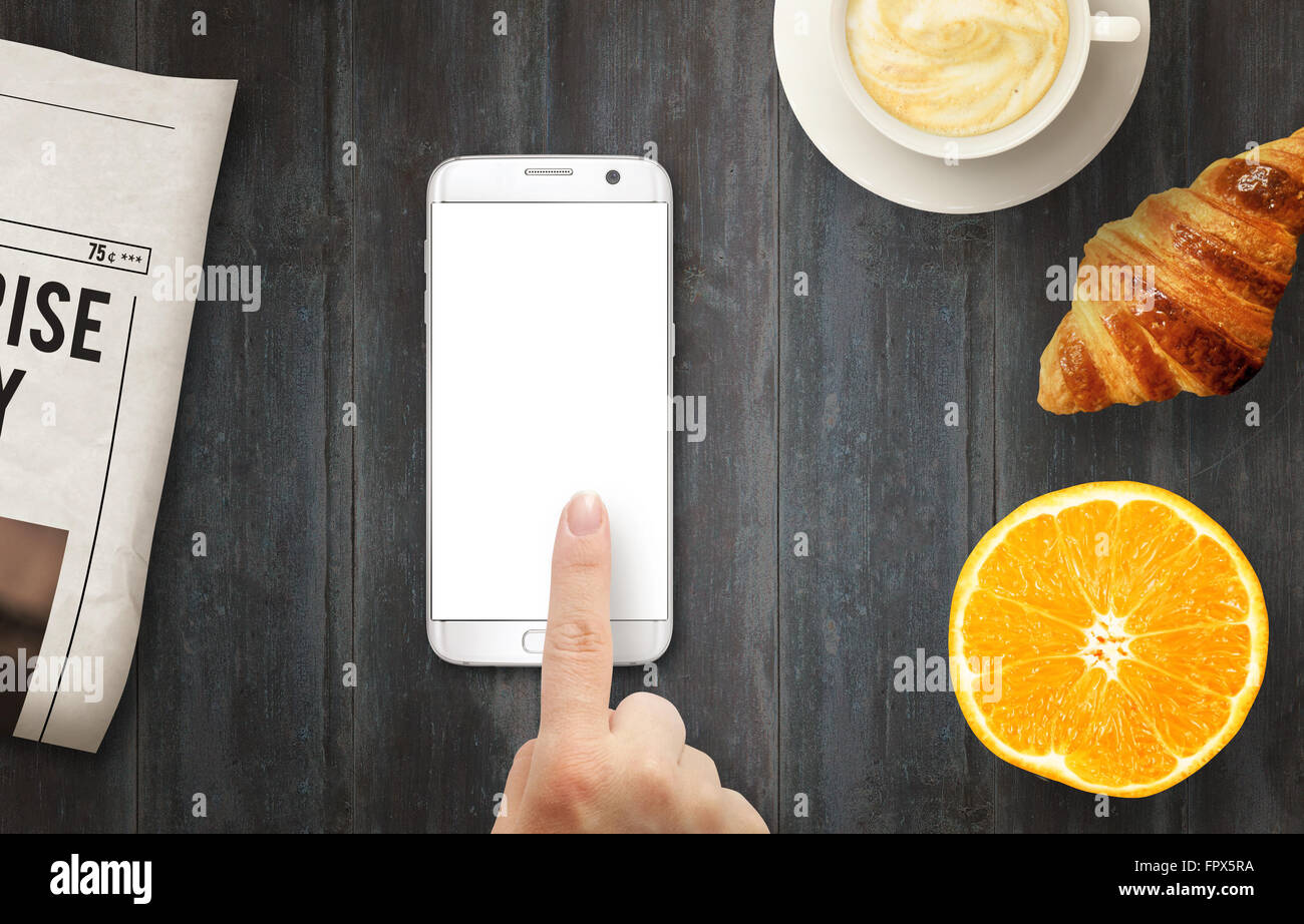 Téléphone intelligent avec affichage isolé pour une maquette. Part de toucher l'écran. Journaux, café, croissant et d'orange sur la table. Vue d'en haut Banque D'Images