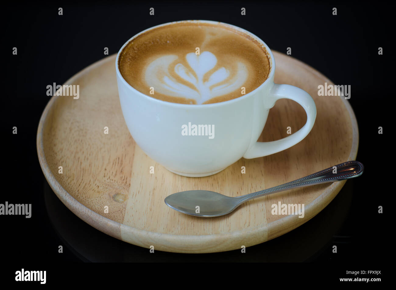 Une tasse de Latte art sur plaque de bois Banque D'Images