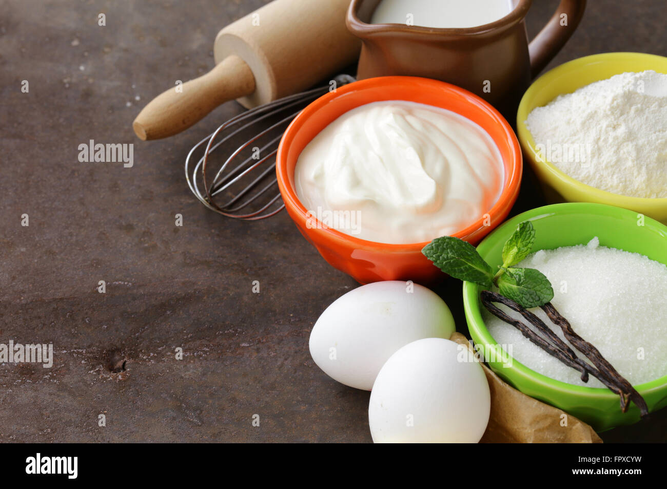 Ingrédients pour pâtisserie - beurre, lait, œufs, farine et sucre vanille sur un fond de bois Banque D'Images