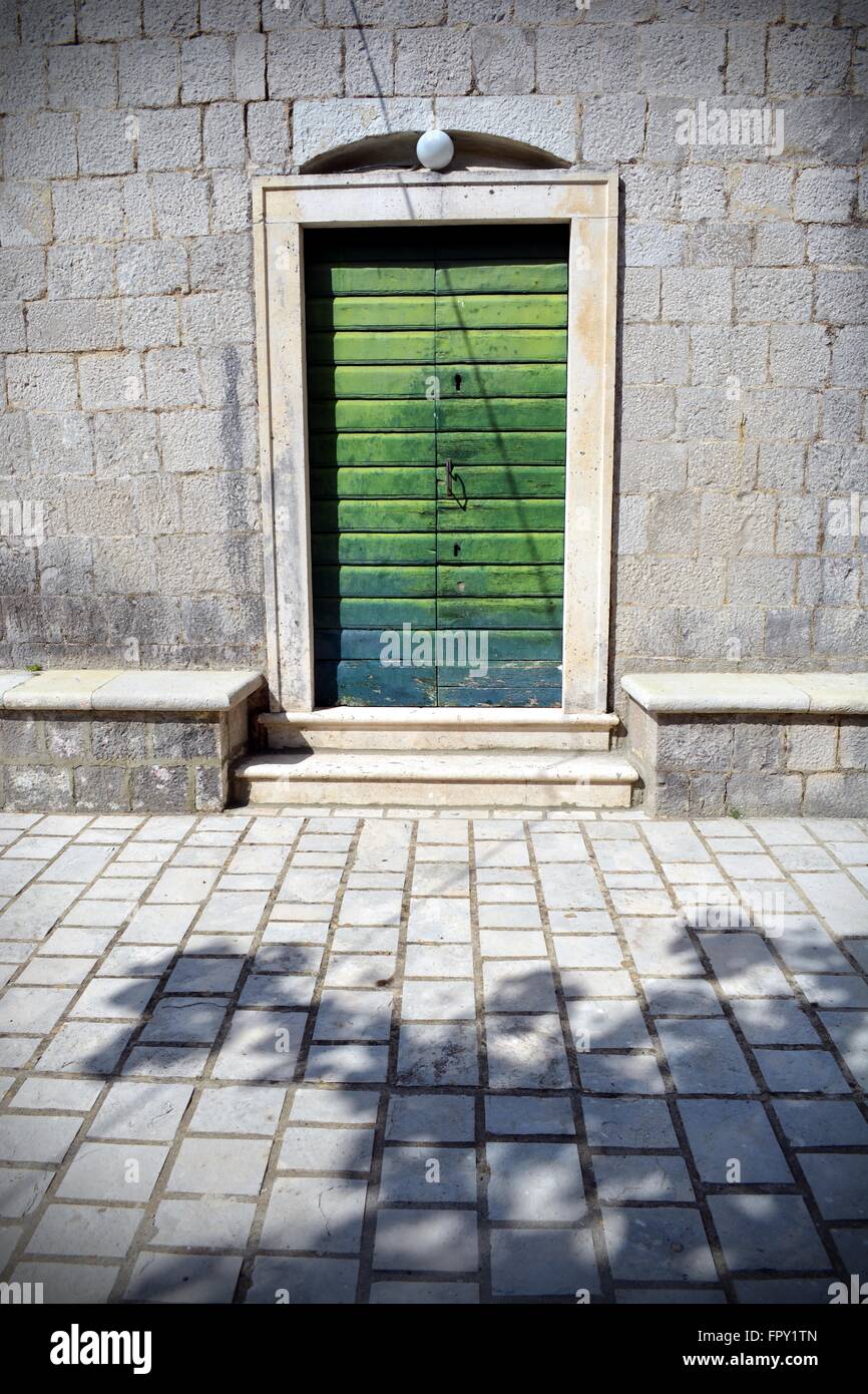 En bois pâle porte verte d'une vieille église en pierre Morinje, baie de Kotor, Monténégro Banque D'Images