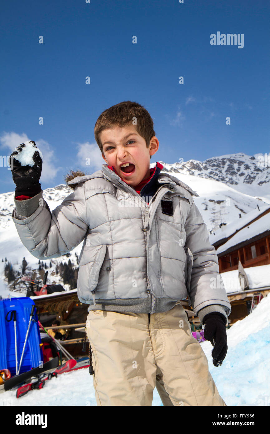 Close up enfant tirant snowball avec fond de ciel bleu Banque D'Images