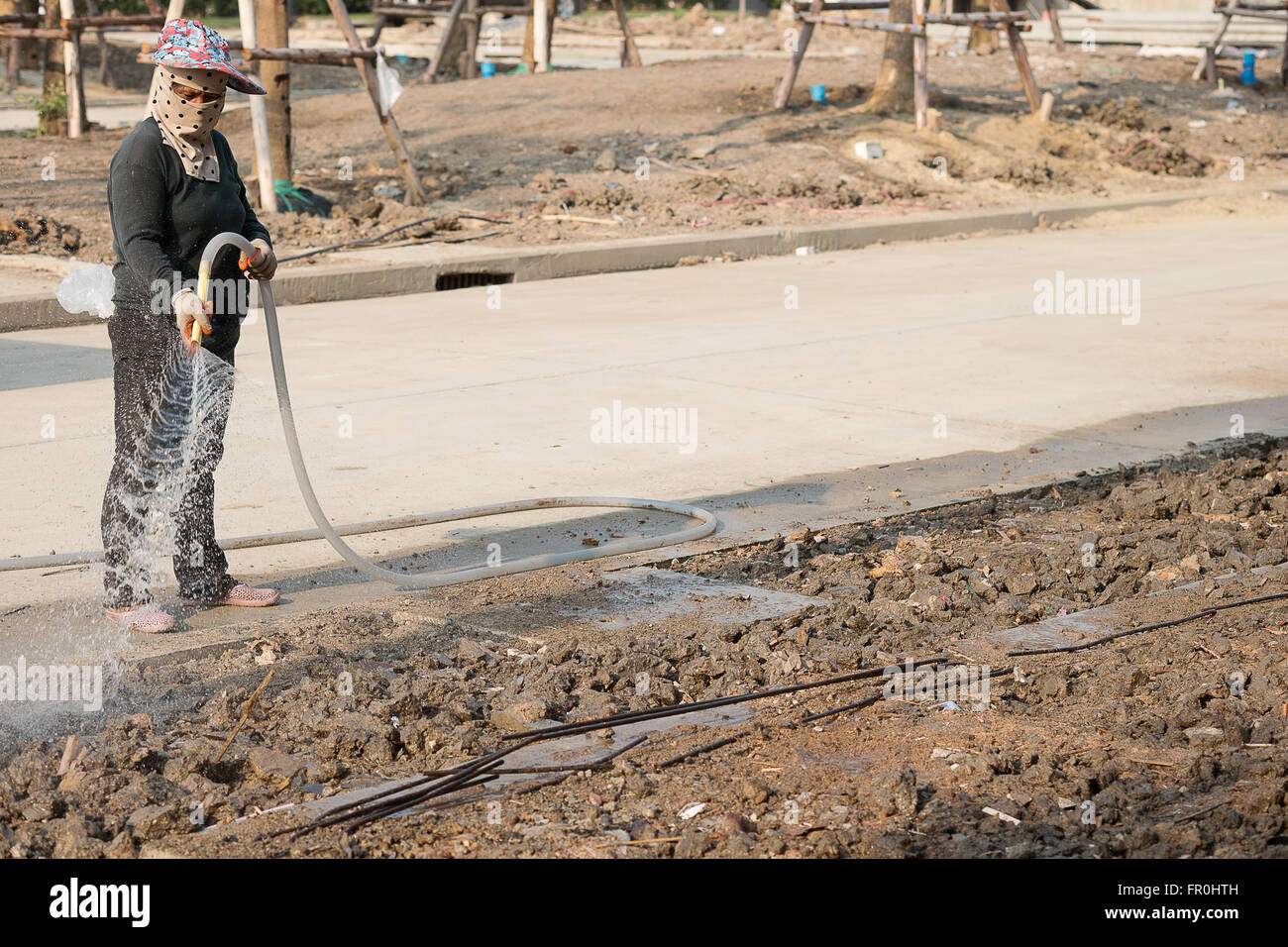 Les femmes dans la main-d'arrosage construction site Banque D'Images