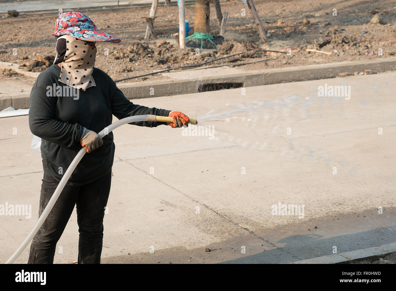 Les femmes dans la main-d'arrosage construction site Banque D'Images