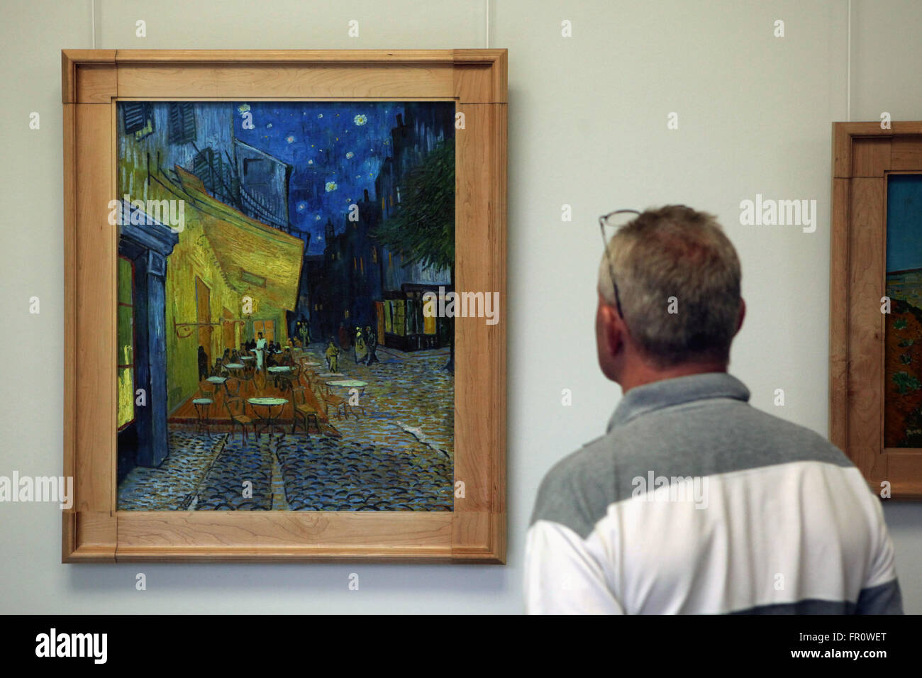 Visiteur regarde la peinture terrasse de café de nuit (1888) de Vincent