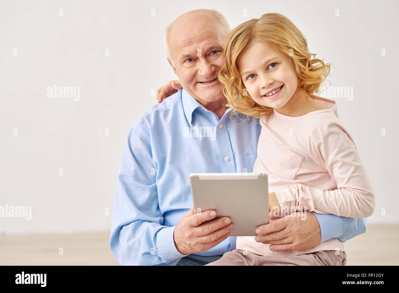 Petite-fille assis avec les grands-parents et de table Banque D'Images