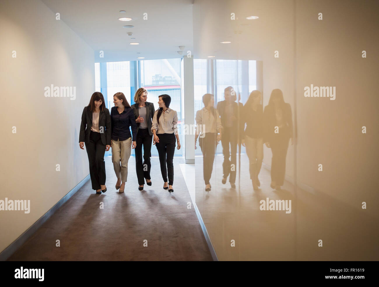 Businesswomen walking in a row in office corridor Banque D'Images