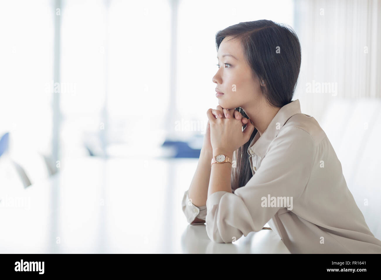 Pensive businesswoman looking away in conference room Banque D'Images