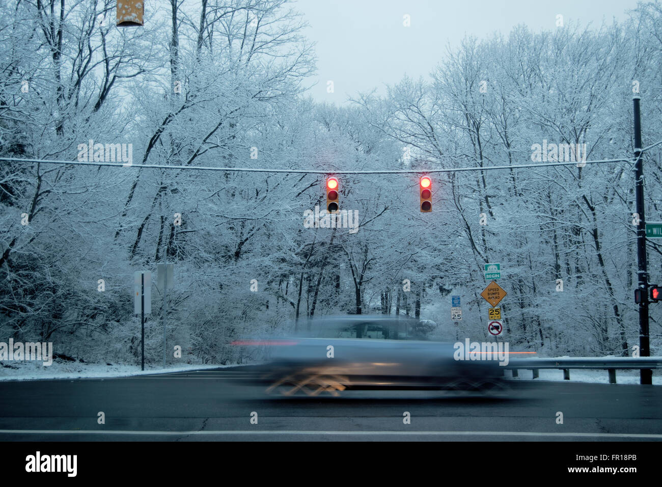 Voiture roulant à travers Feu vert sur jour de neige Banque D'Images