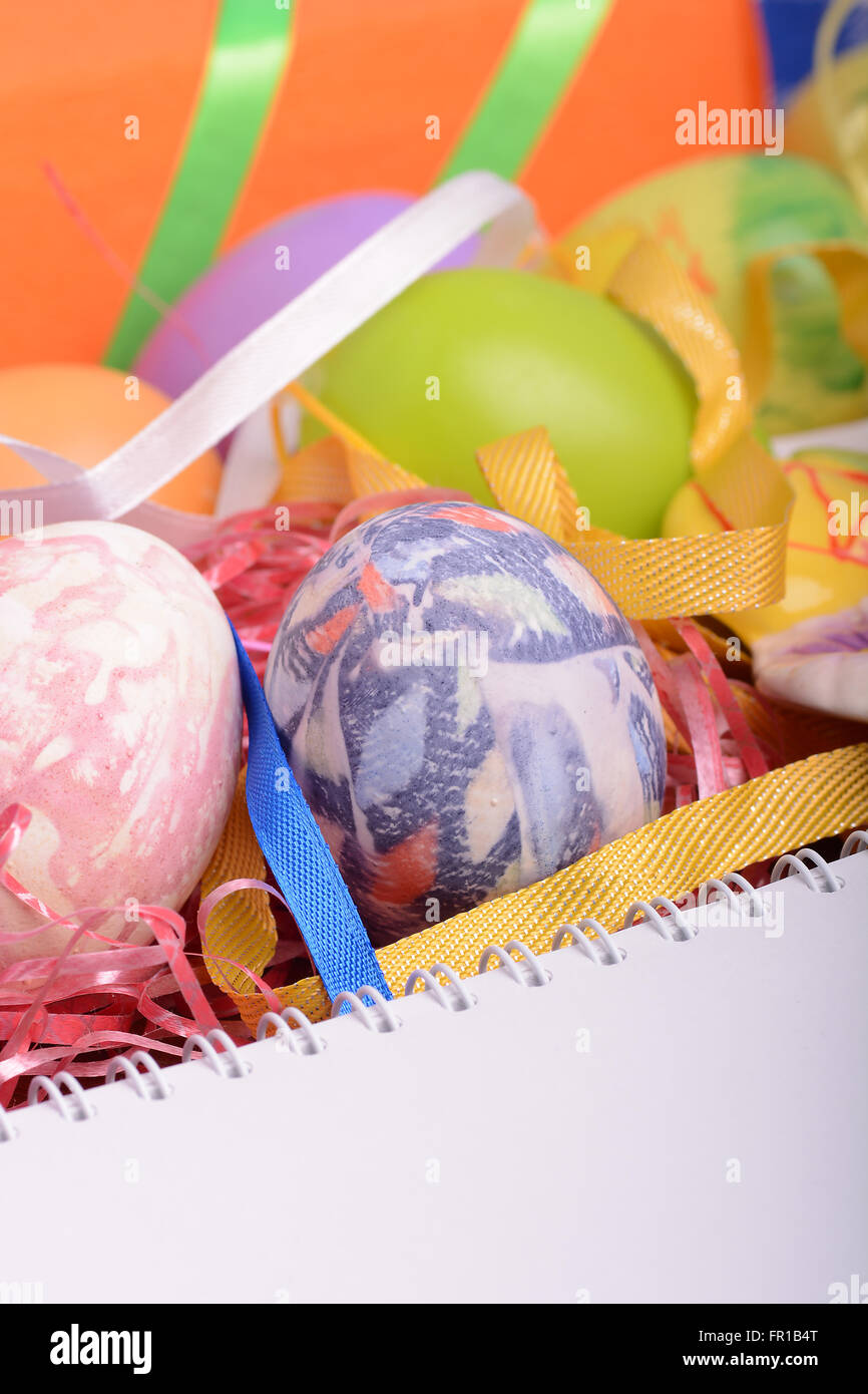Arrangement des boîtes-cadeaux dans du papier d'emballage avec des rubans à carreaux et d'oeufs de Pâques décorés isolé sur fond blanc Banque D'Images