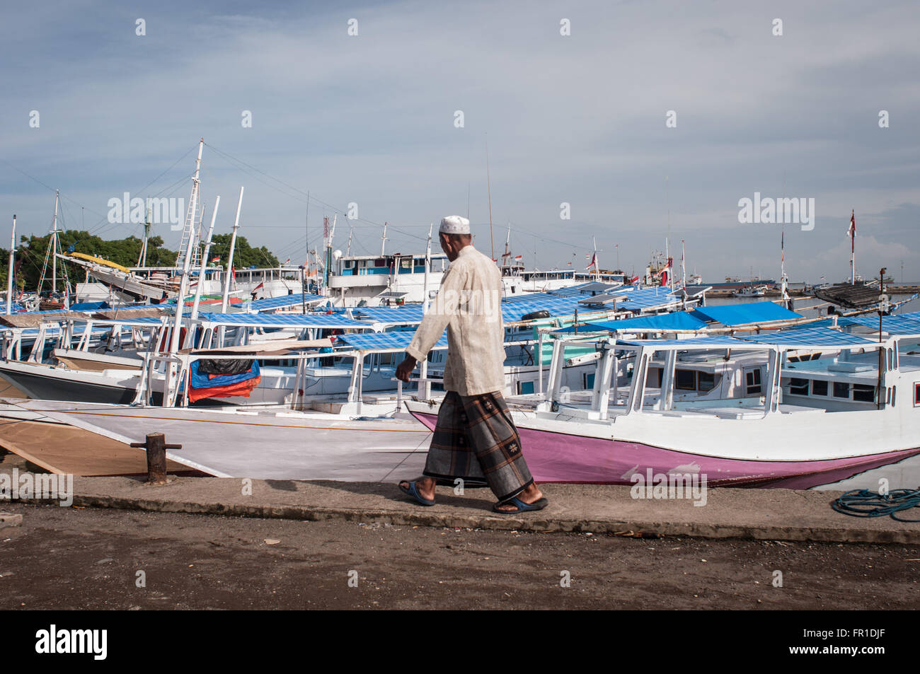 Un homme marche devant achored Paotere bateaux à Port. Le Port de Paotere bien connu comme un vieux port. Banque D'Images