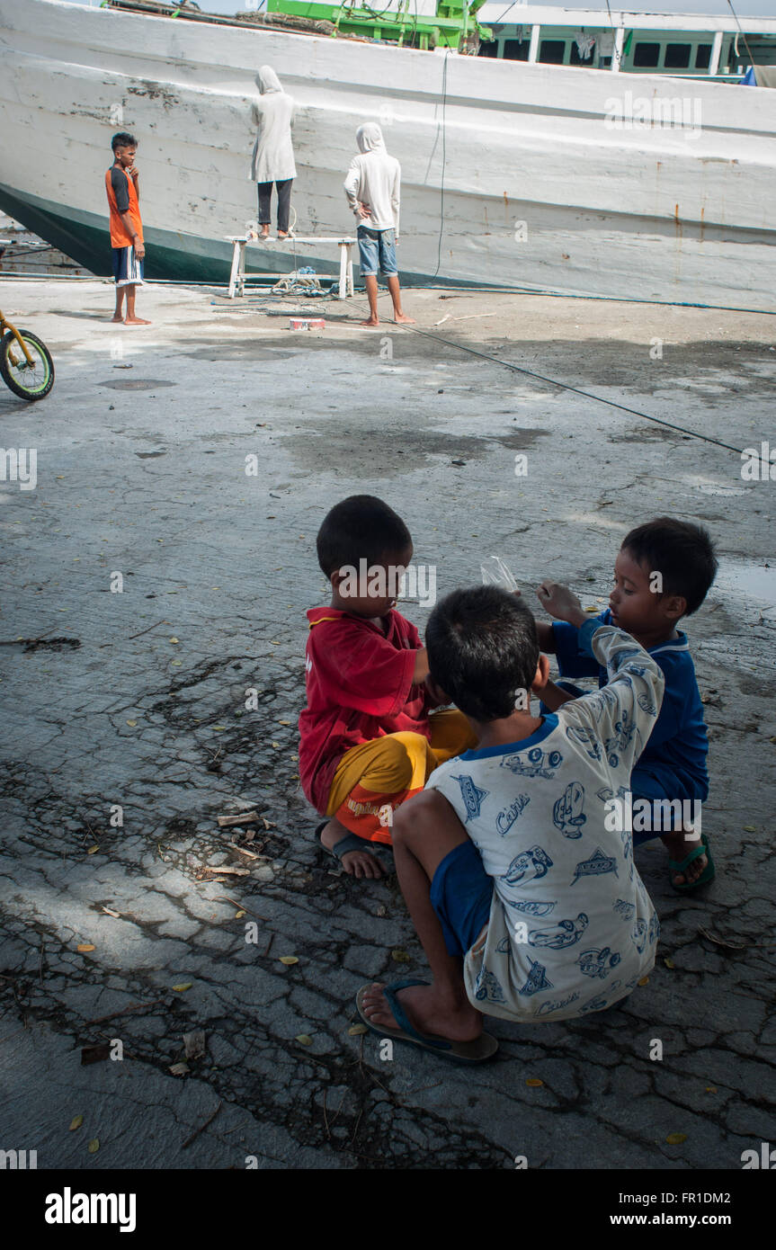 Trois garçons jouent au Port de Paotere. Le Port de Paotere bien connu comme un vieux port et devenir l'un des endroit touristique à Makassar. Banque D'Images