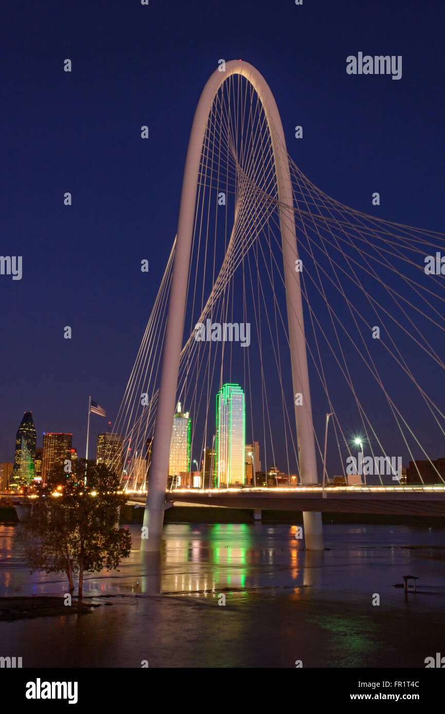 Dallas Skyline avec Margaret Hunt Hill Bridge en premier plan, ciel bleu clair et la réflexion dans les eaux de crue de la rivière Trinity. Coucher du soleil Banque D'Images