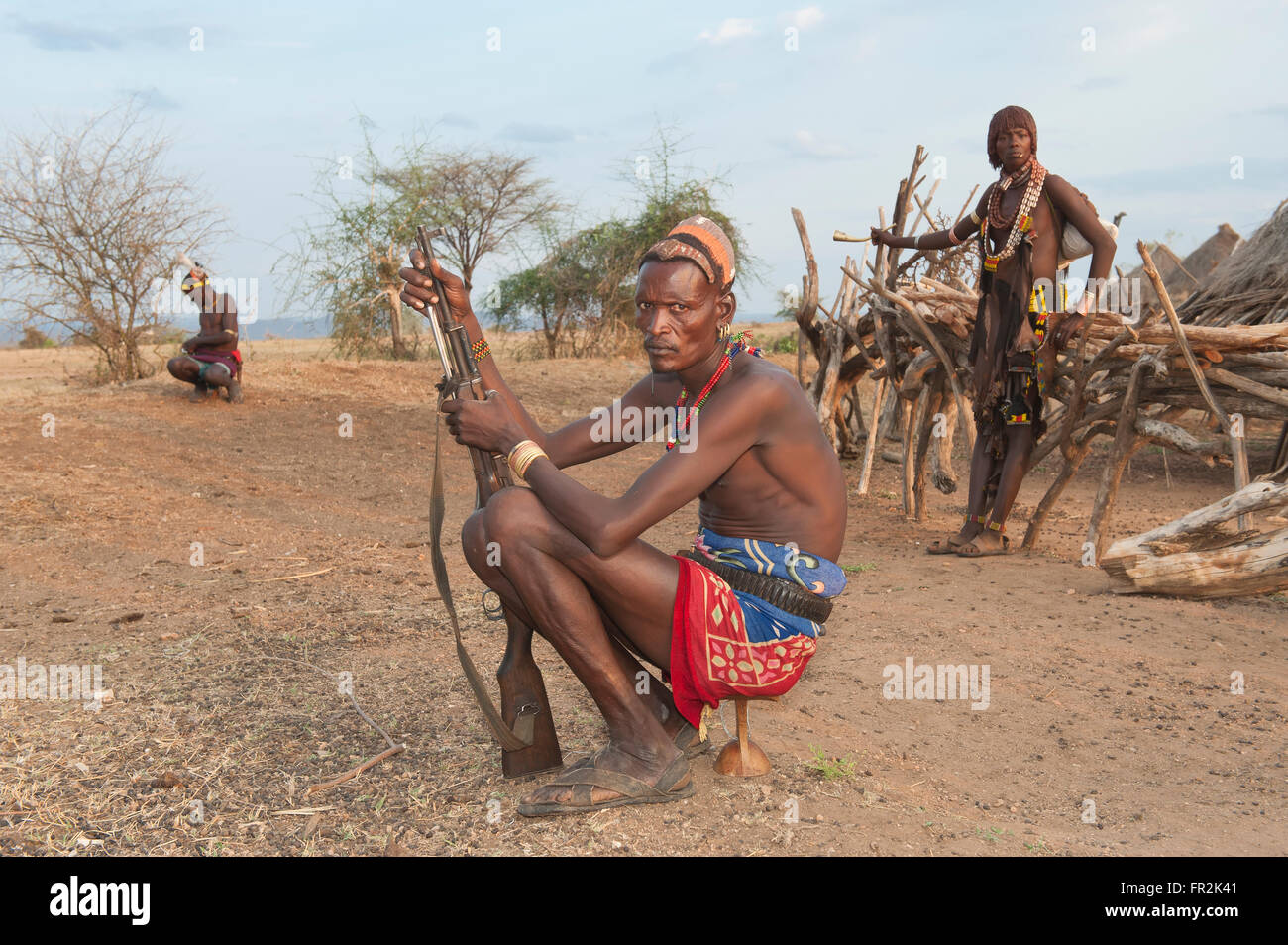 Hamar guerrier avec la coiffure traditionnelle faite d'argile et d'un fusil assis sur son appui-tête, la vallée de la rivière Omo, en Ethiopie Banque D'Images