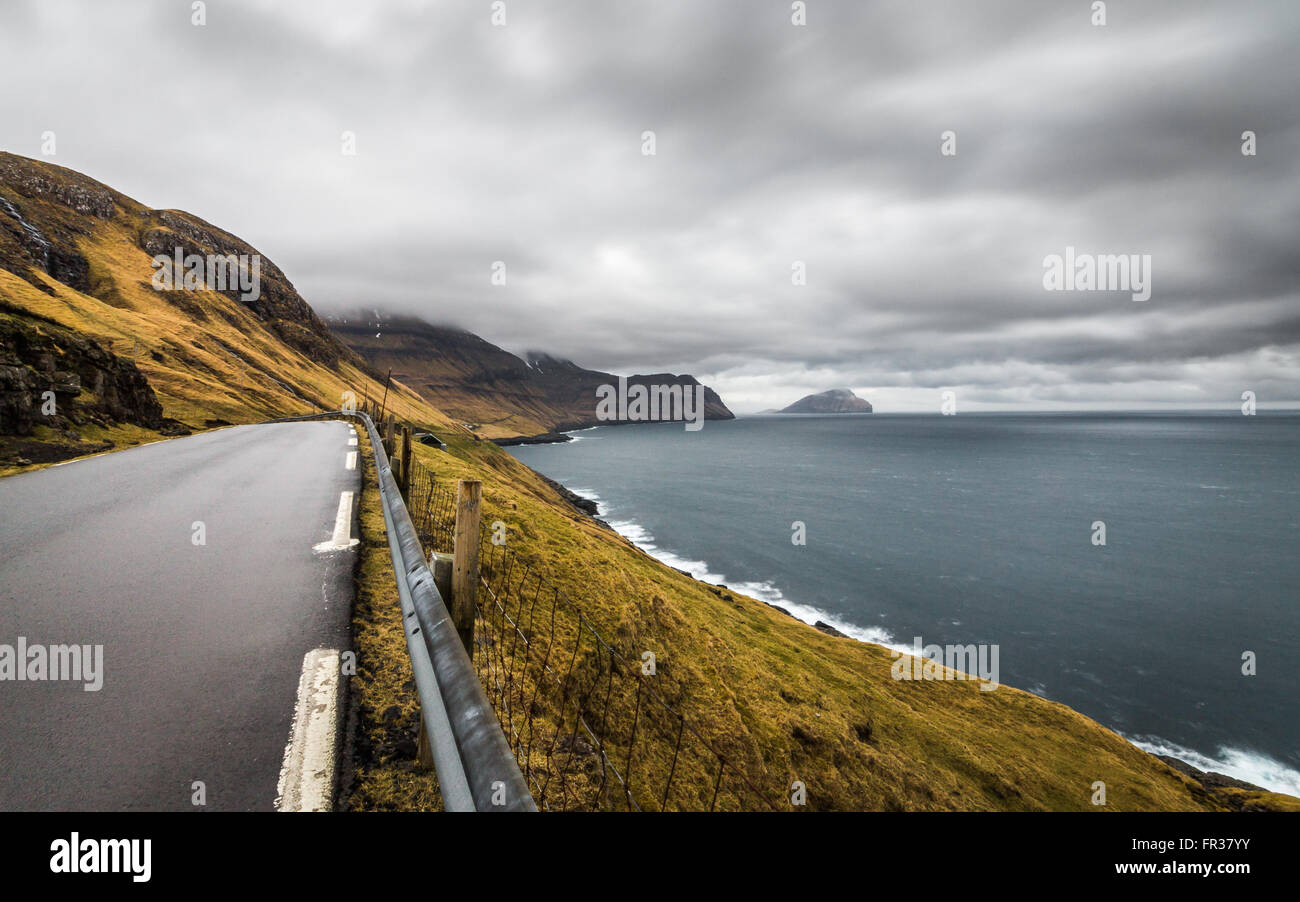 Soir nuageux et venteux de la route, l'île de l'océan et dans l'horizon. Îles Féroé, Danemark, Europe Banque D'Images