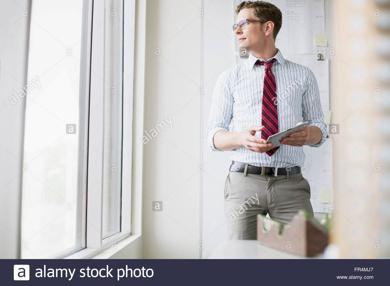 Jeune professionnel avec tablette pc à la fenêtre du bureau Banque D'Images