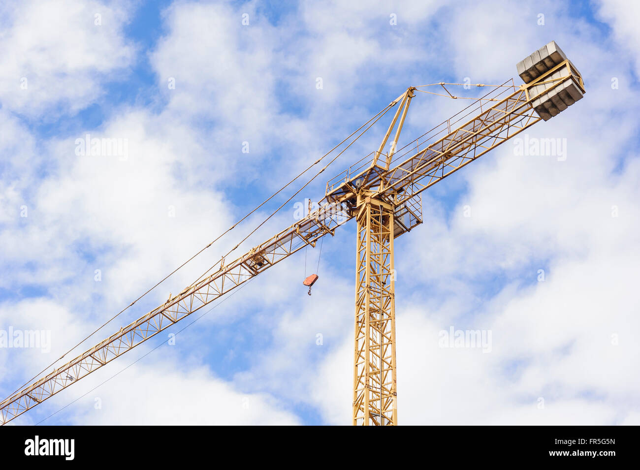 Grue industrielle jaune working on Construction Site contre le ciel bleu Banque D'Images
