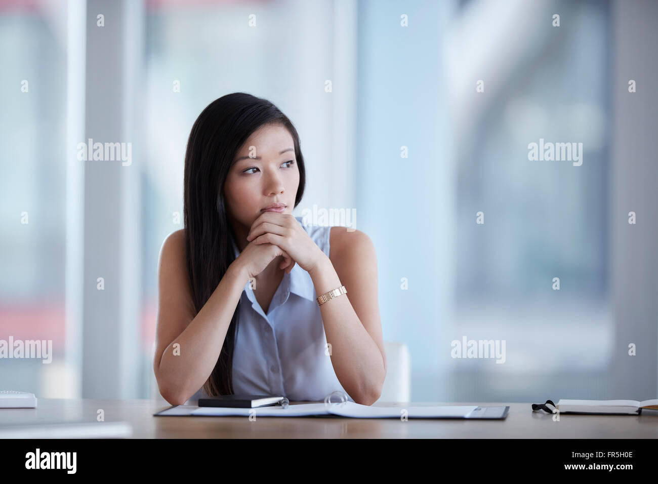 Pensive businesswoman looking away in conference room Banque D'Images