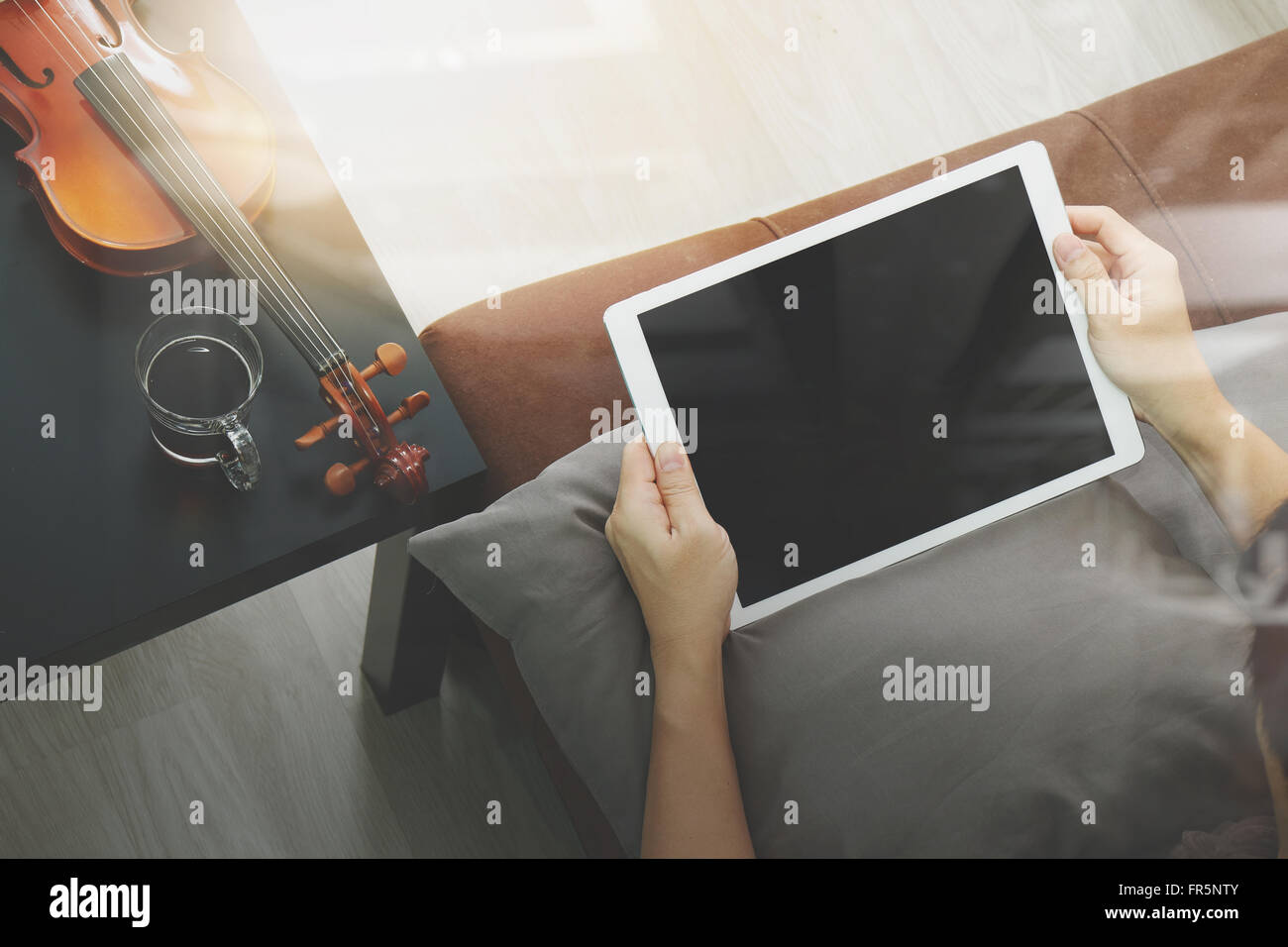 Hipster part composer la musique avec tablette numérique compter et sitting on sofa at home studio Banque D'Images