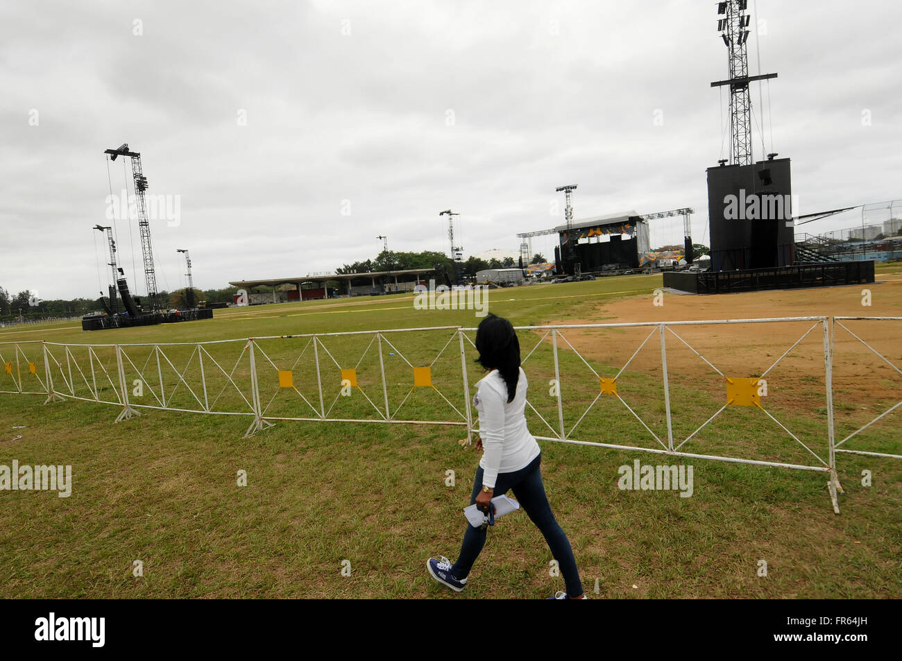 La Havane, Cuba. 21 mars, 2016. Une femme marche par la Ciudad Deportiva de La Havane, Cuba où une scène et des tours pour la lumière et les haut-parleurs ont été installés en prévision du prochain concert des Rolling Stones. Une foule d'environ 500 000 $ est prévu pour l'événement gratuit qui est prévue pour le 25 mars 2016, après avoir été reportée du 20 mars 2016 en raison de l'arrivée à La Havane du président américain Barack Obama à cette date. La bande expédiés 61 conteneurs d'environ 500 tonnes de matériel à Cuba afin de rendre le concert sans précédent possible. Crédit : Paul Hennessy/Alamy Live News Banque D'Images