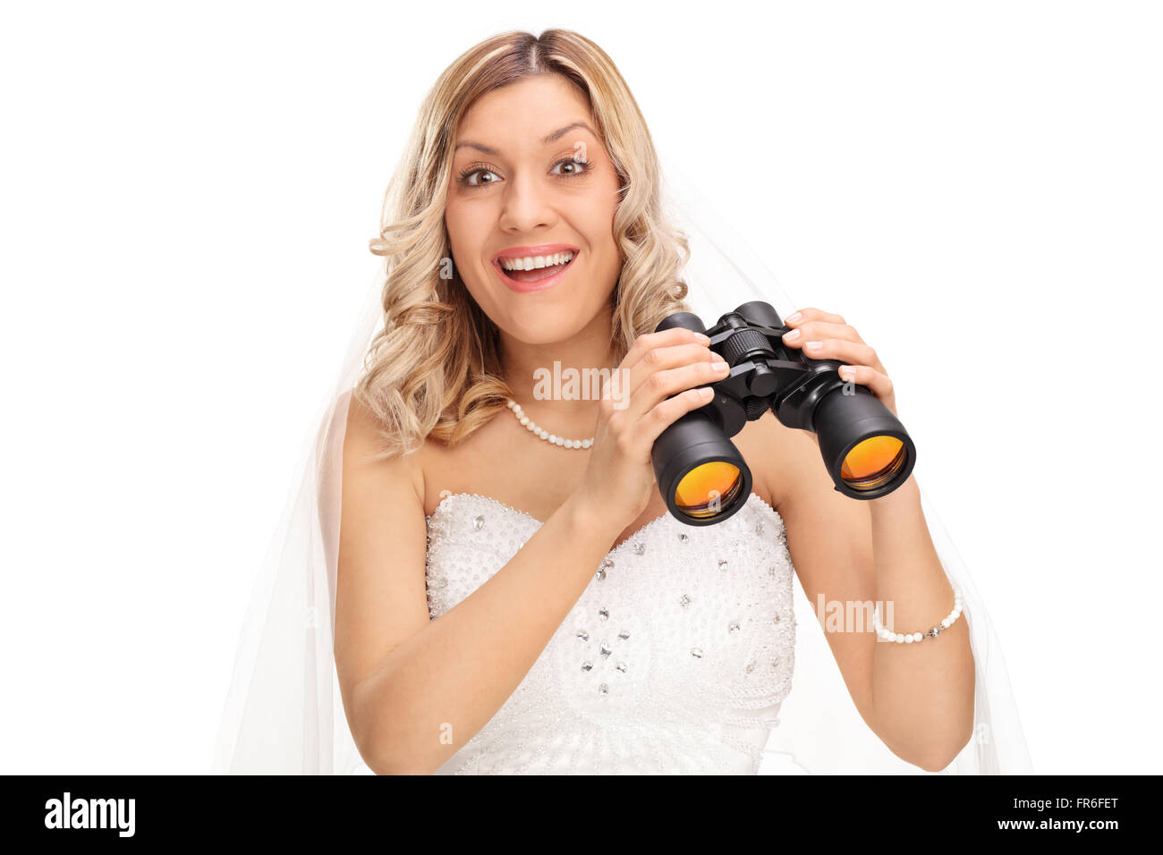 Jeune mariée joyeuse tenant une paire de jumelles et regardant la caméra isolé sur fond blanc Banque D'Images
