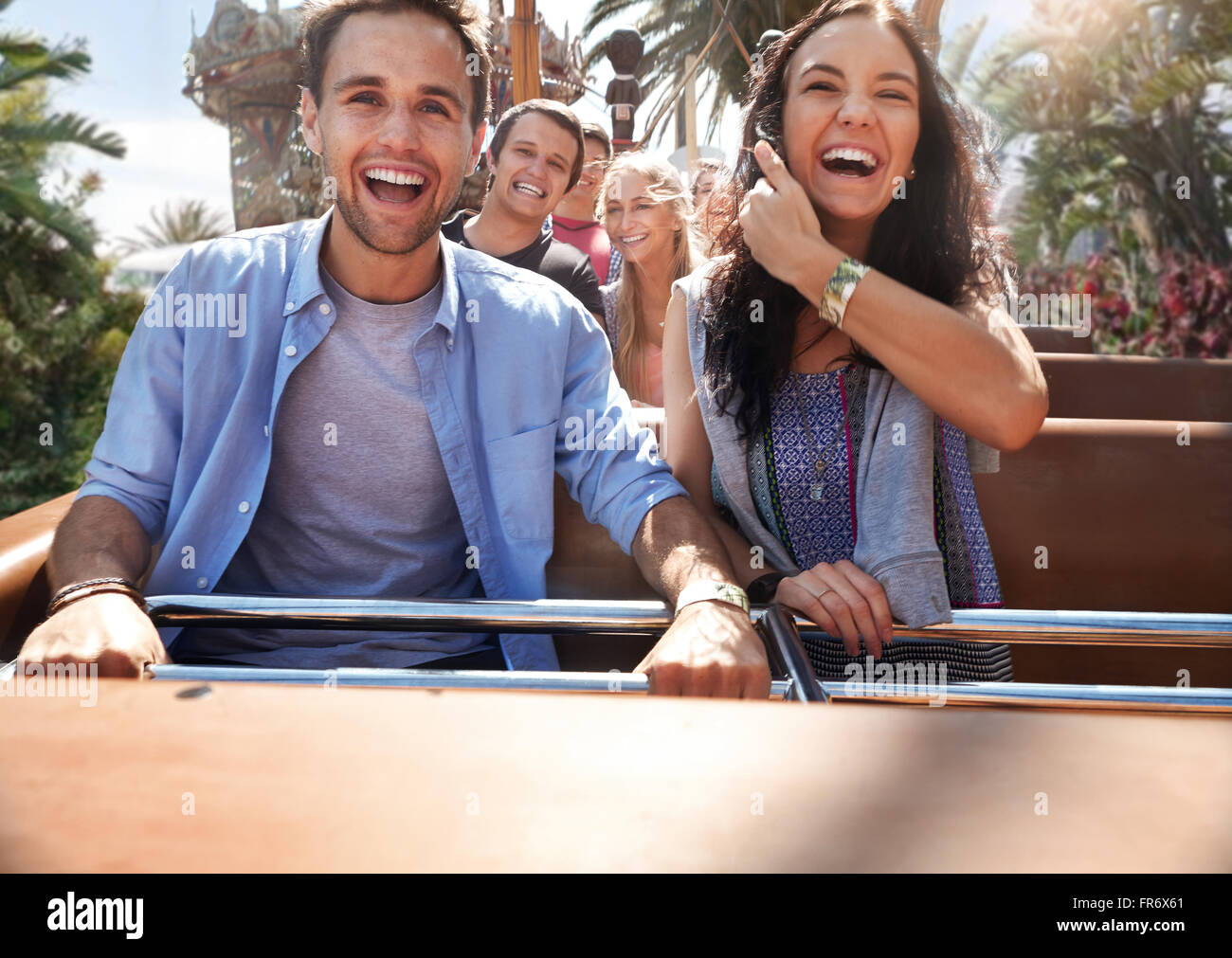 Les jeunes enthousiastes couple riding amusement park ride Banque D'Images