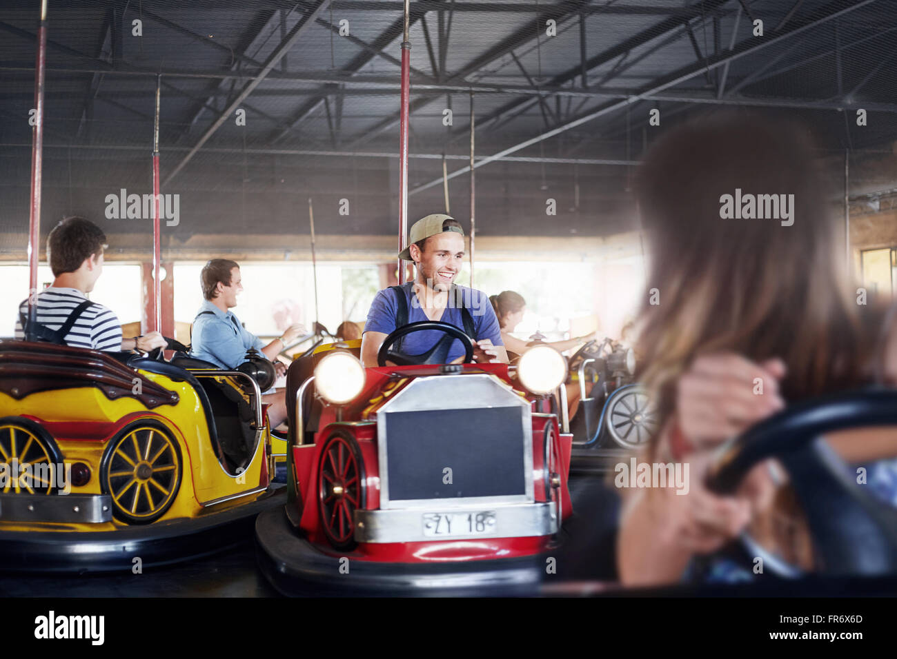 Jeune homme équitation voitures de butoir à amusement park Banque D'Images