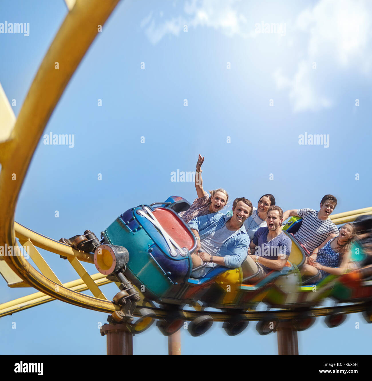 Encourager les amis équitation roller coaster at amusement park Banque D'Images
