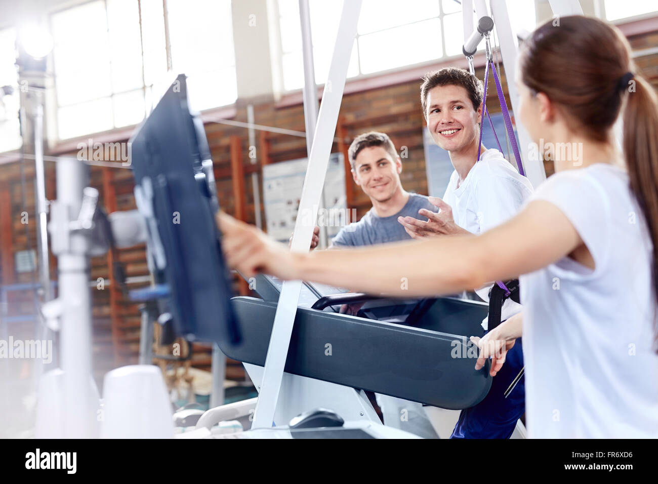 Les thérapeutes physiques avec l'homme sur tapis roulant Banque D'Images
