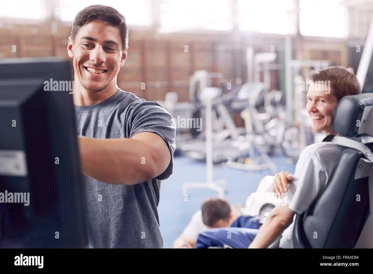 Thérapeute physique à l'ordinateur de parler à l'homme Banque D'Images