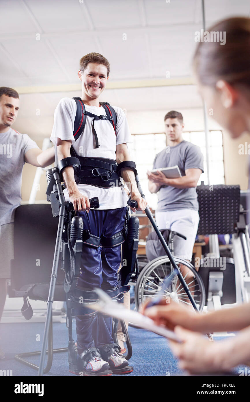 Smiling man avec l'avant bras béquilles en physiothérapie Banque D'Images