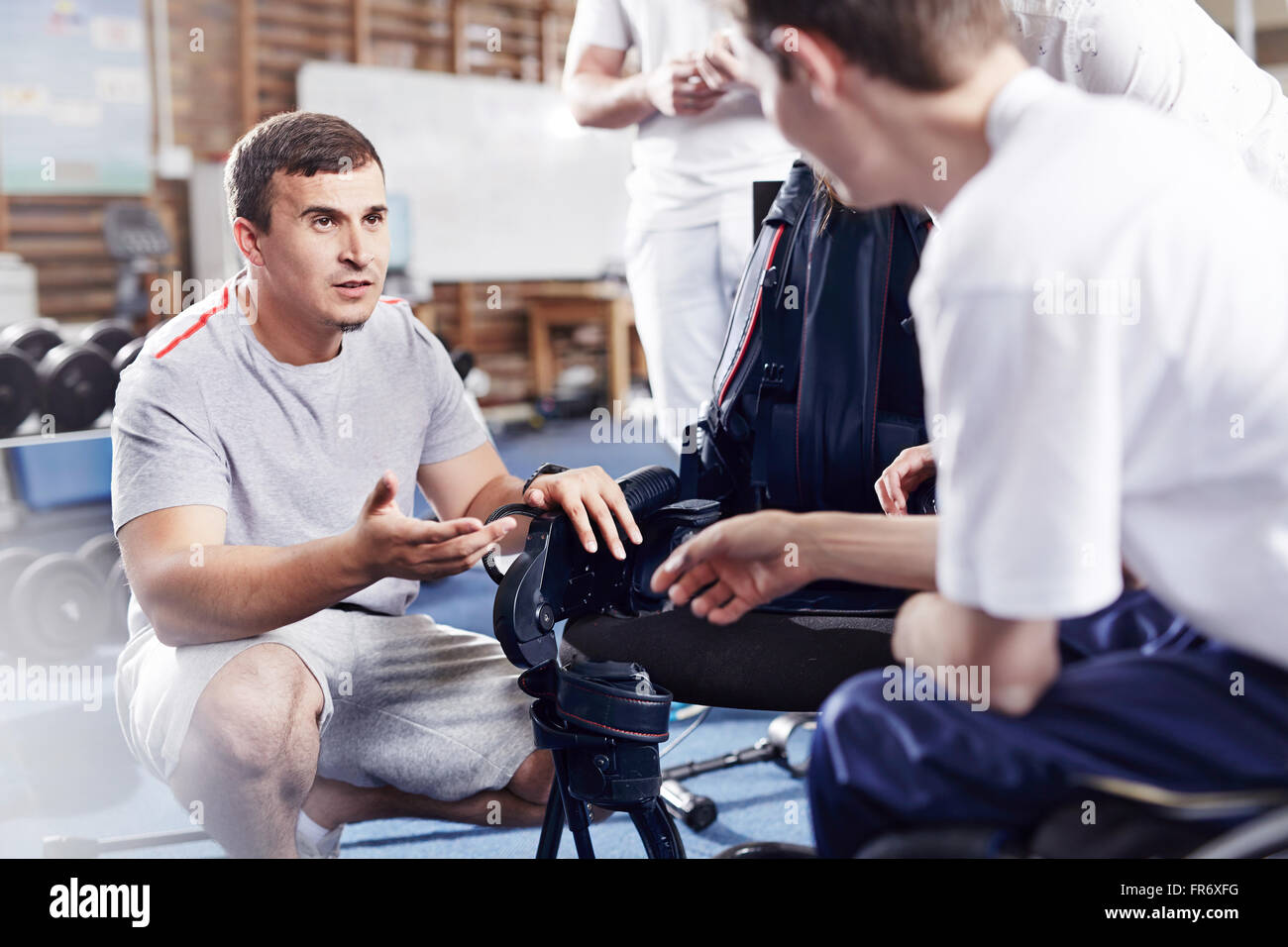 Thérapeute physique expliquant à l'homme de l'équipement Banque D'Images