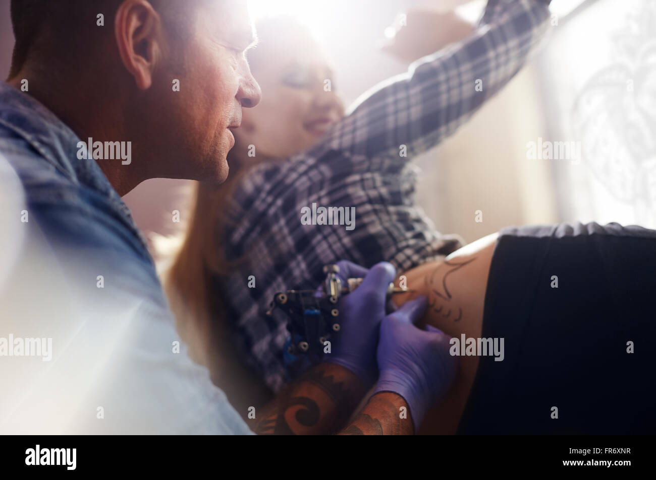 Artiste de tatouage tatouage woman's hip Banque D'Images Artiste de tatouage tatouage woman's hip Banque D'Images