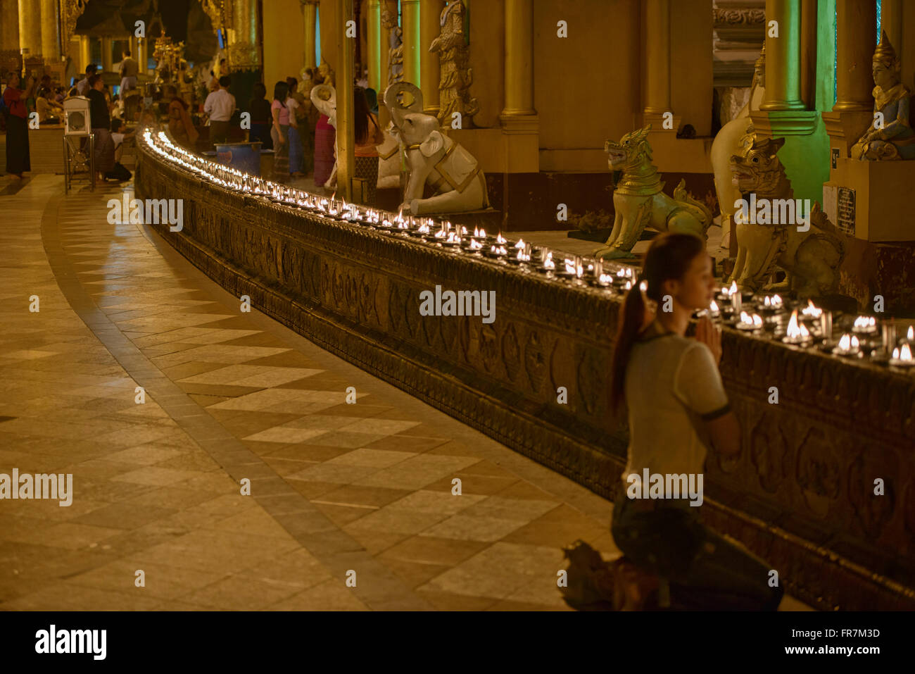 Pèlerin priant en vertu de bougies à la pagode Shwedagon Paya, le lieu saint à Yangon, Myanmar Banque D'Images