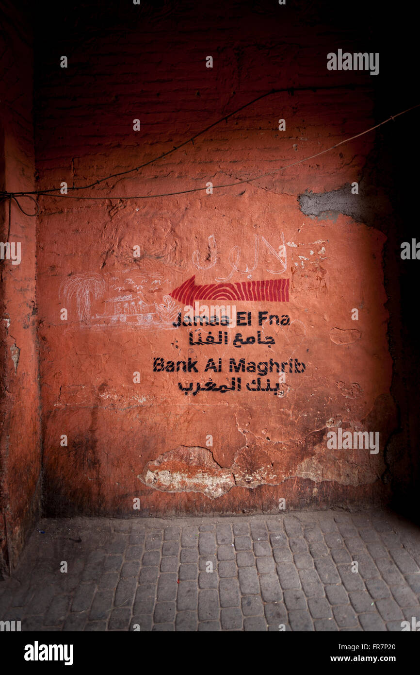 Inscription peinte sur mur pointant vers une ruelle sombre dans une banque, Marrakech, Maroc Banque D'Images