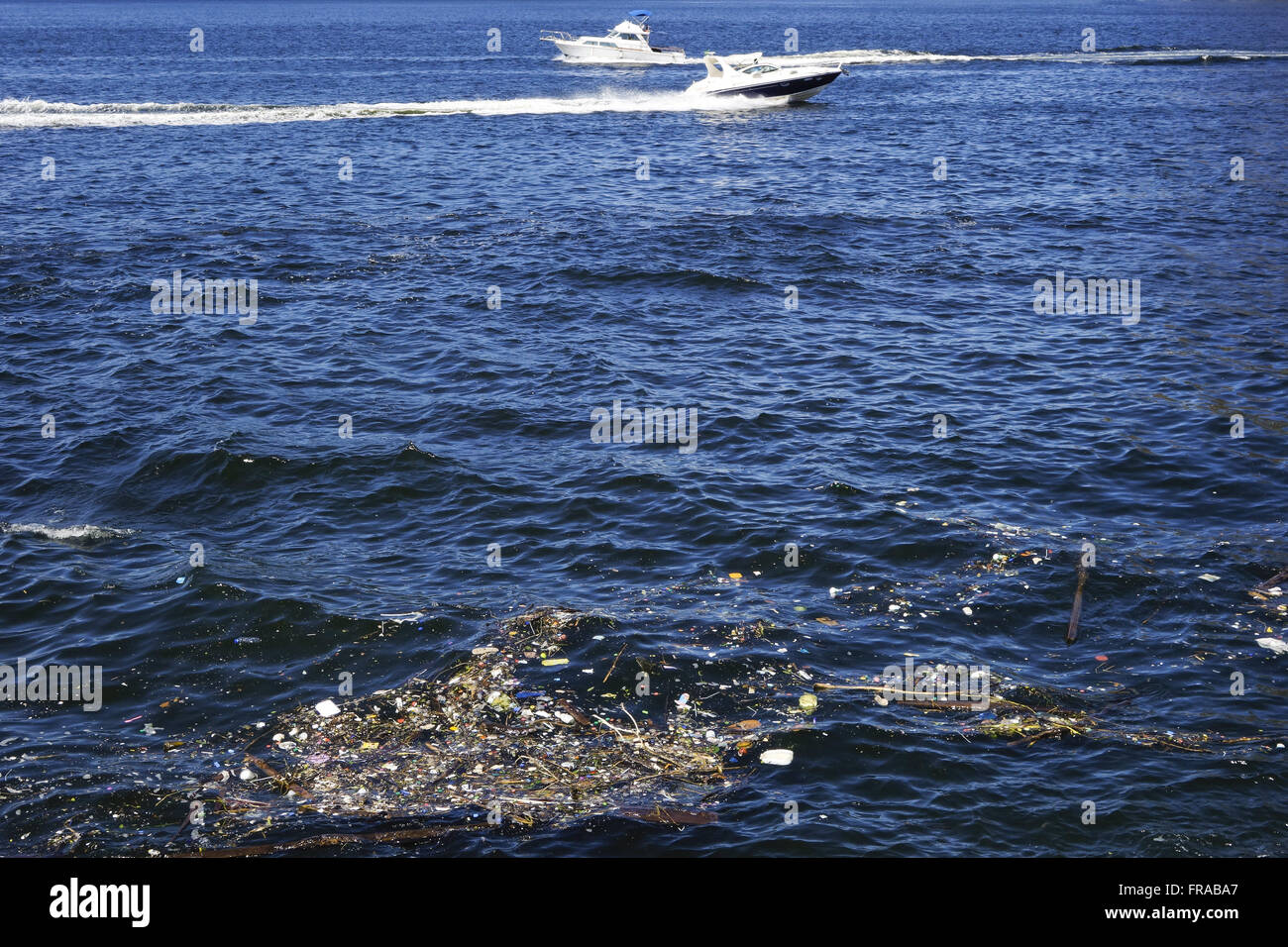 Corbeille jeté dans la mer avec des bateaux marche sur le bord inférieur du Flamengo Banque D'Images