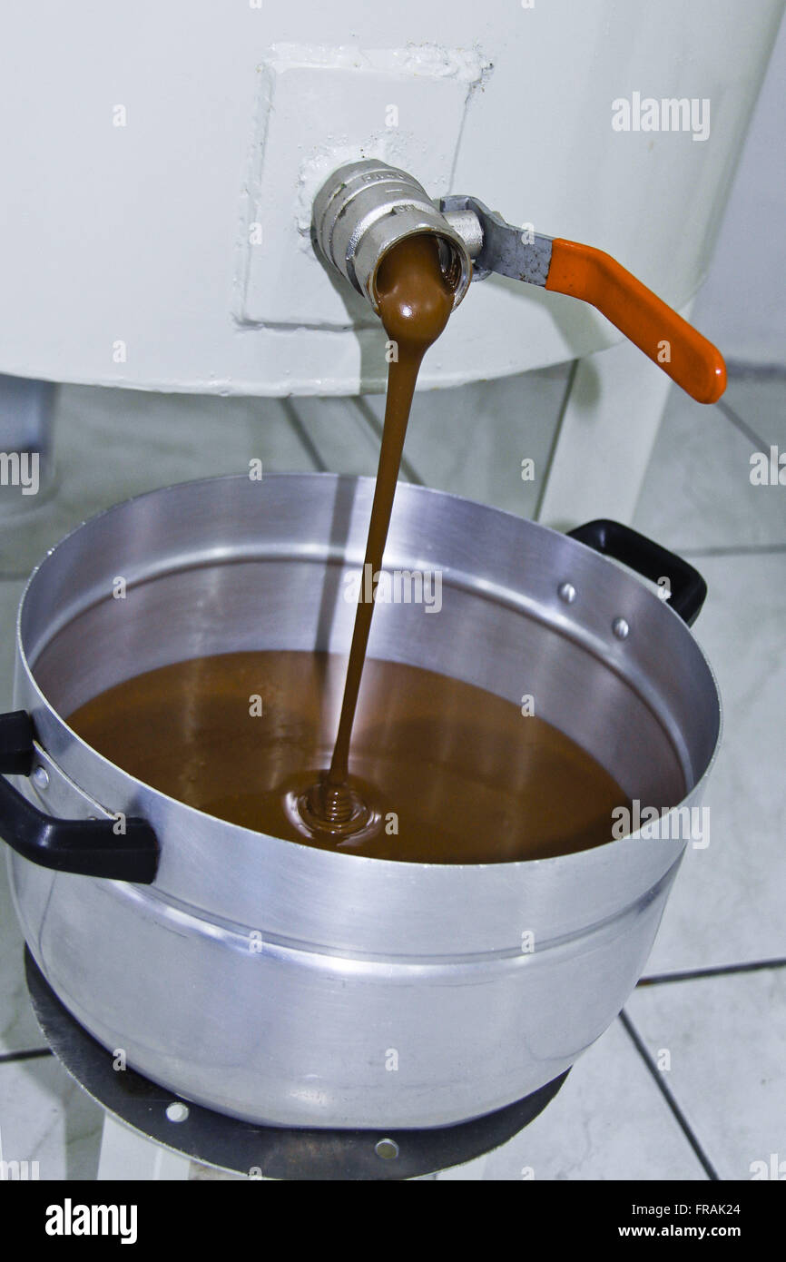La production artisanale de chocolats - le chocolat à la température idéale étant retiré de derretedeira Banque D'Images