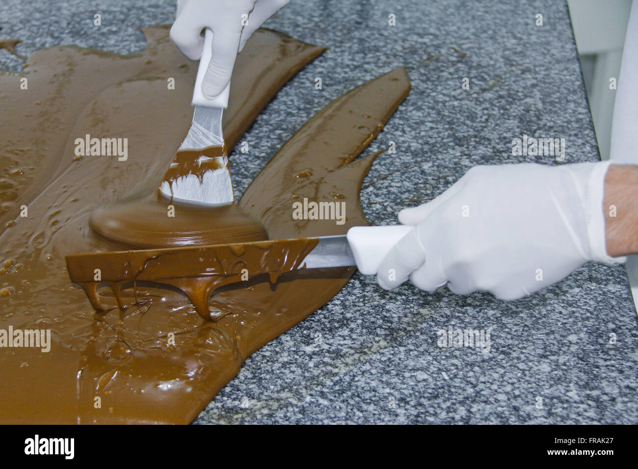 La production artisanale de chocolats - tempérer le chocolat pour couvrir Banque D'Images