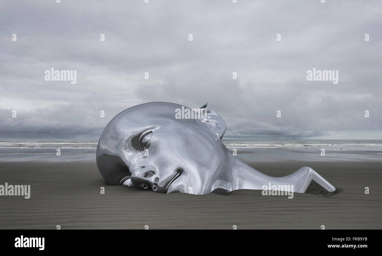 Tête chrome géant en partie submergé dans le sable sur une plage déserte Banque D'Images