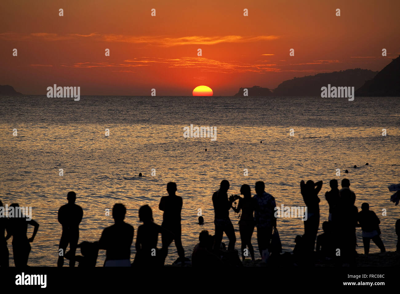 Les gens qui regardent un coucher de soleil sur la plage d'Ipanema Banque D'Images