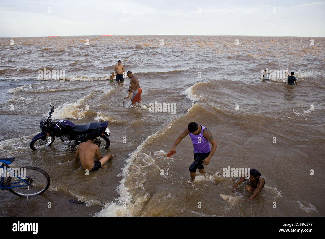 Man le vélo et les gens se baigner dans le fleuve Amazone - Rampe Santa Ines Banque D'Images