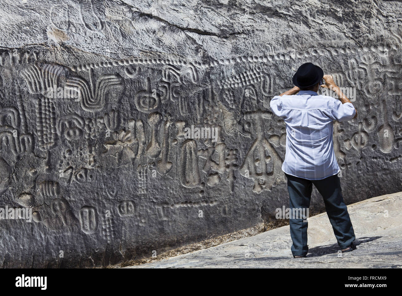 Fotografa Turista itacoatiaras na Pedra do Ingá - sítio arqueológico Banque D'Images