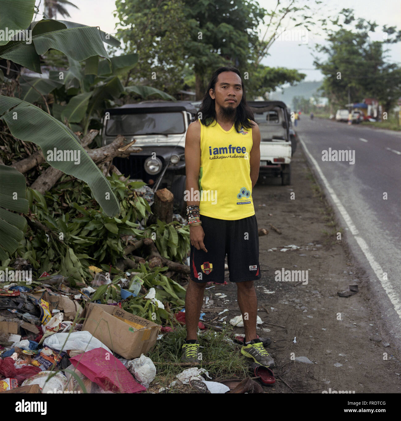 Tacloban, Philippines - 6 janvier 2014 : un ingénieur civil sur son jogging le long de Maharlika Autoroute, Tacloban, Leyte. Banque D'Images