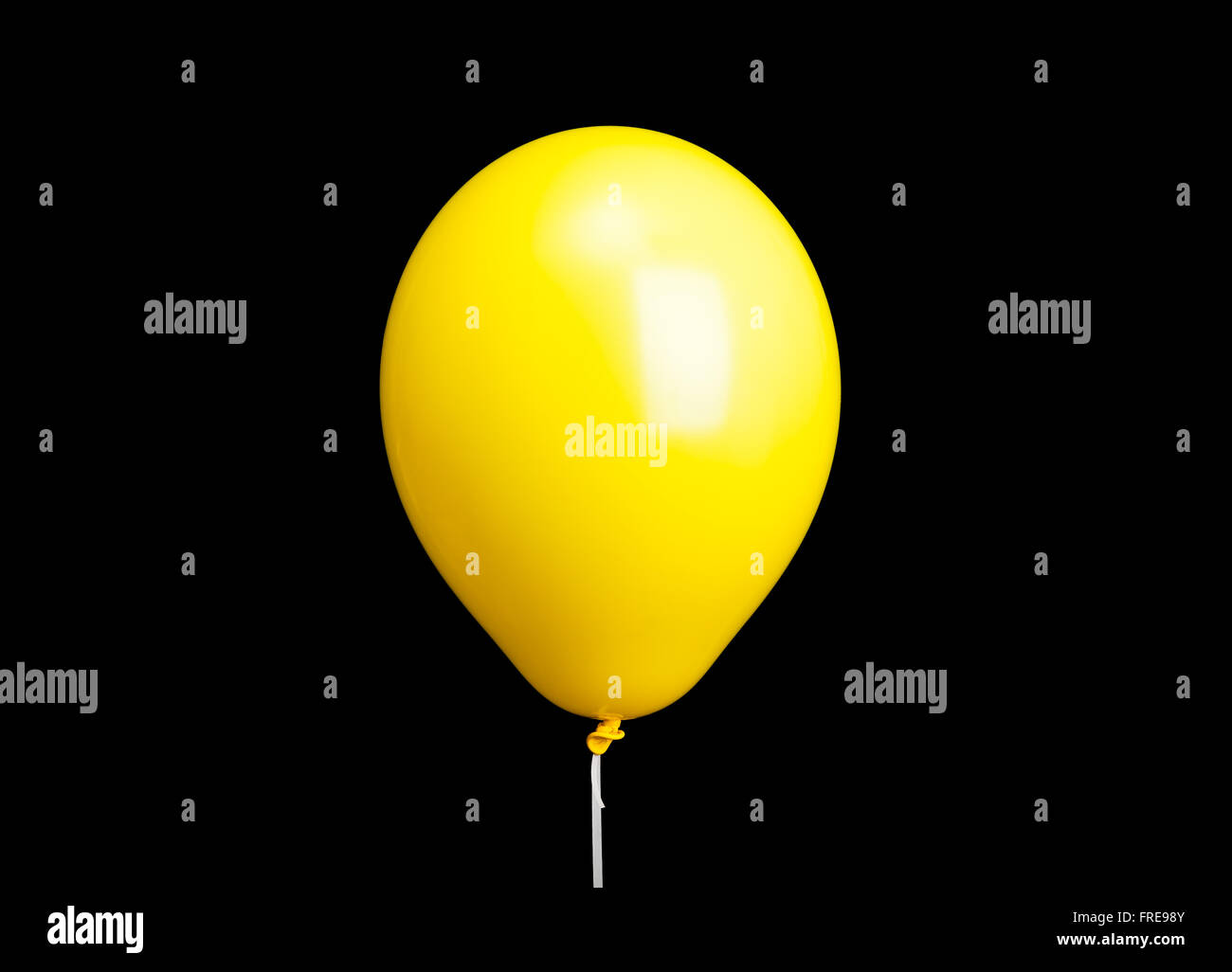 Ballon jaune sur ruban blanc isolé sur fond noir Banque D'Images