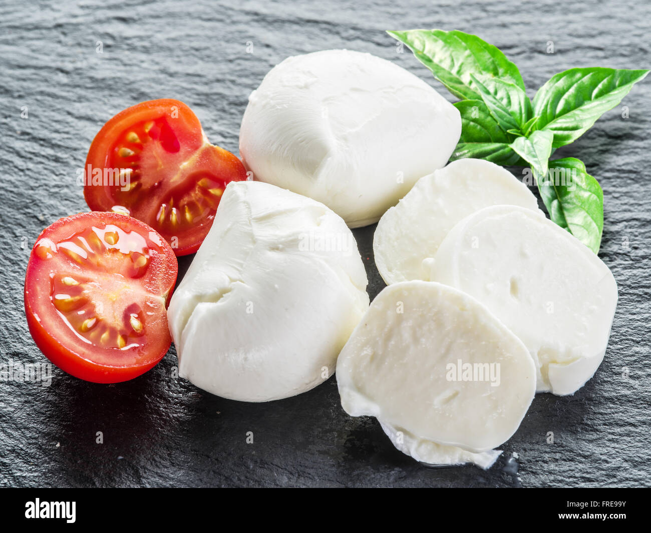 La mozzarella et les tomates. Fond gris foncé. Banque D'Images