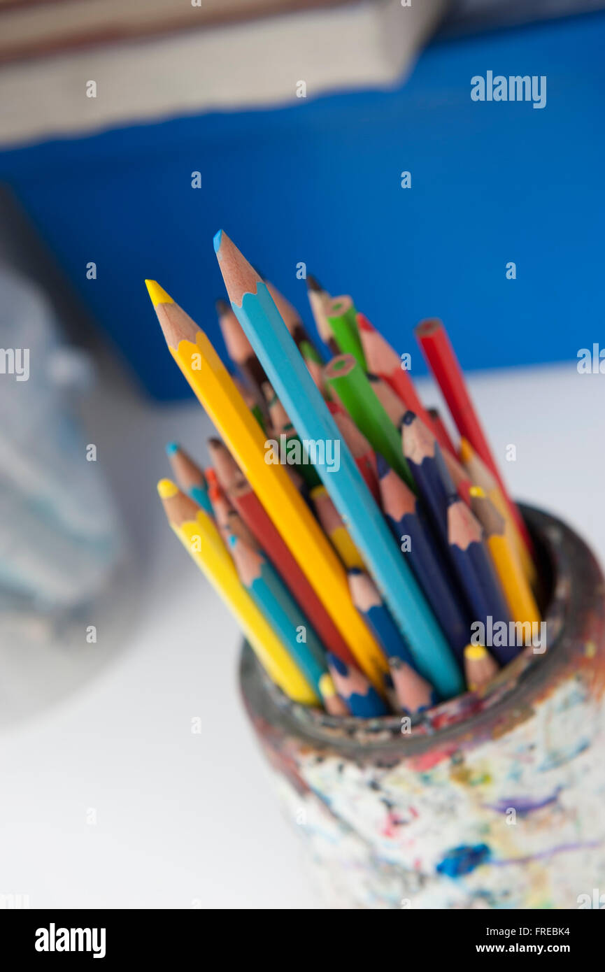 Crayons de couleur dans un pot de peinture-souillée Banque D'Images