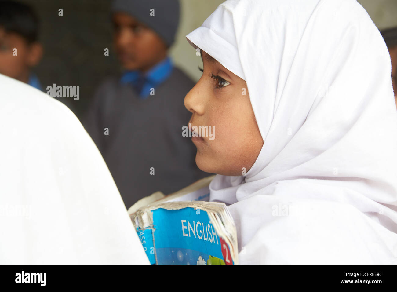 Fille avec un livre l'apprentissage de l'anglais dans une école primaire, Mahey, Pakistan Banque D'Images