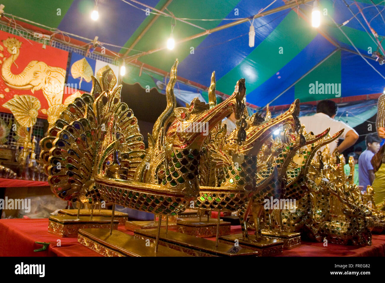 Objets y compris têtes de dragon d'or de Thaïlande sont à vendre dans une rue juste à Kampong Cham, au Cambodge. Banque D'Images