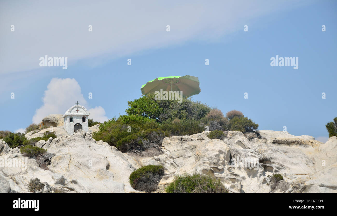 Petite chapelle en pierre sur les roches de la mer Méditerranée et bush de conifères et parasol Banque D'Images