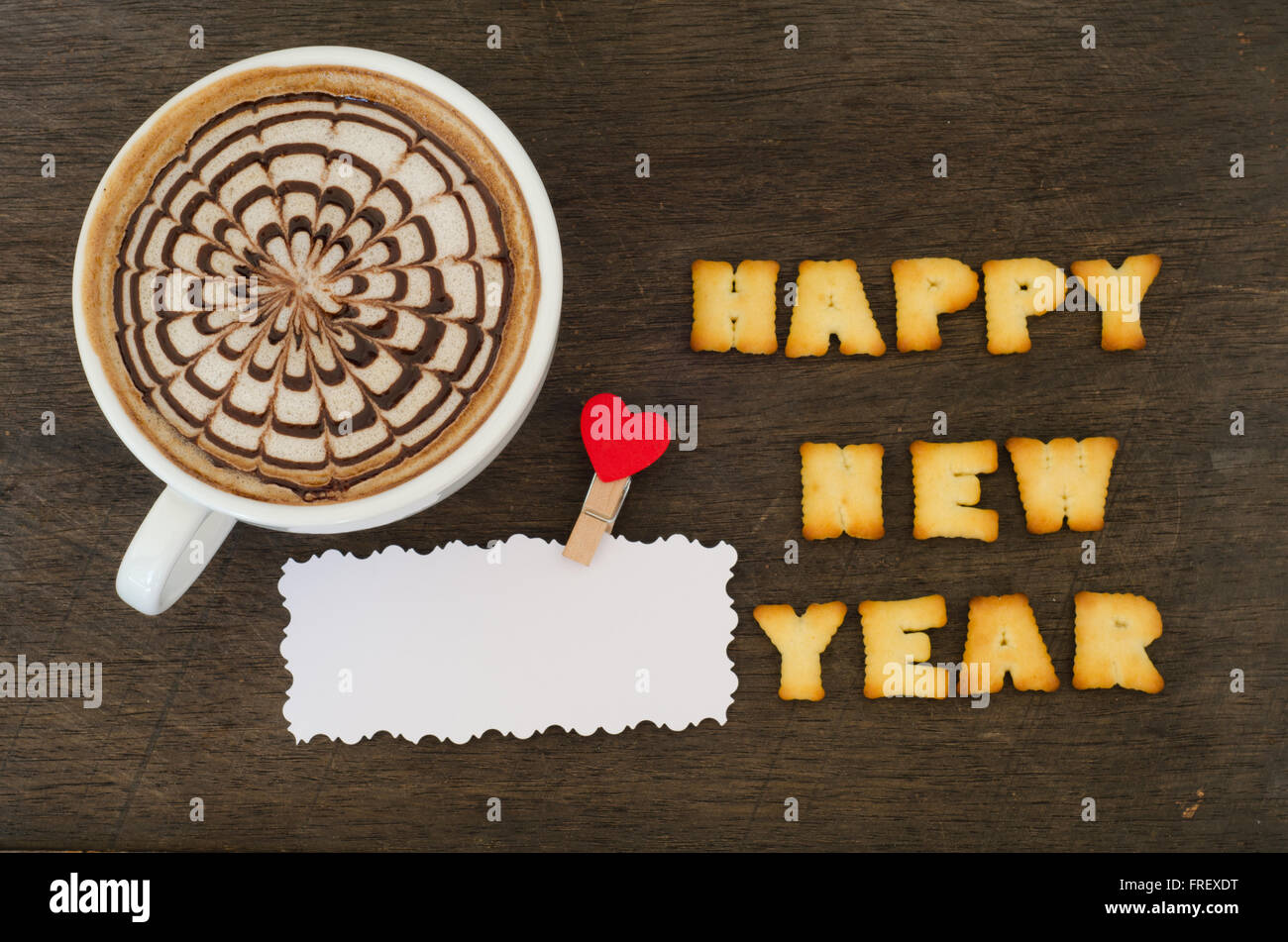Une tasse de Latte art et de l'alphabet "happy new year" fait de cookies pain Banque D'Images