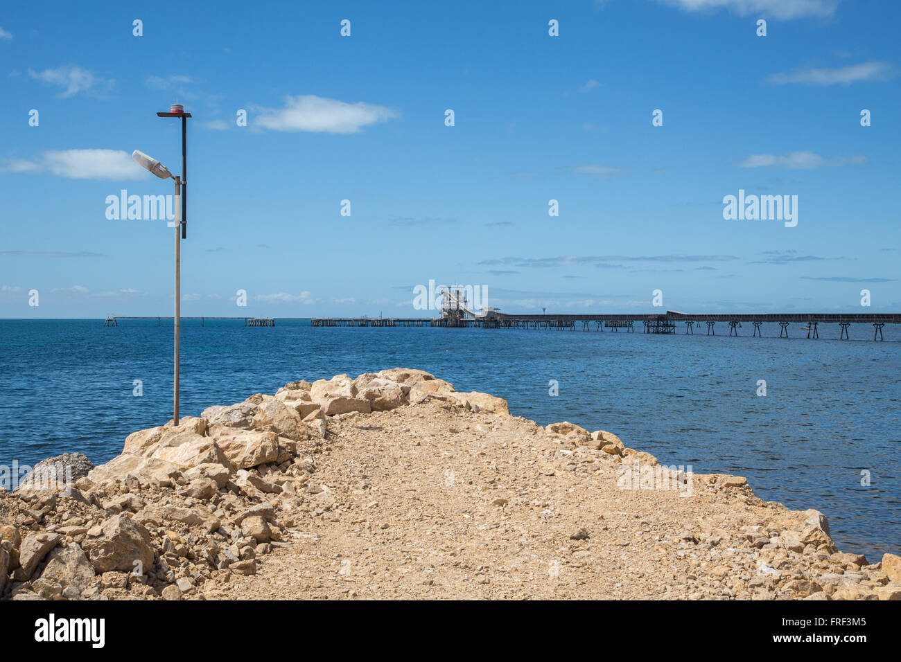 Remblai rock récemment construit qui s'avance dans la mer lisse avec jetty Banque D'Images